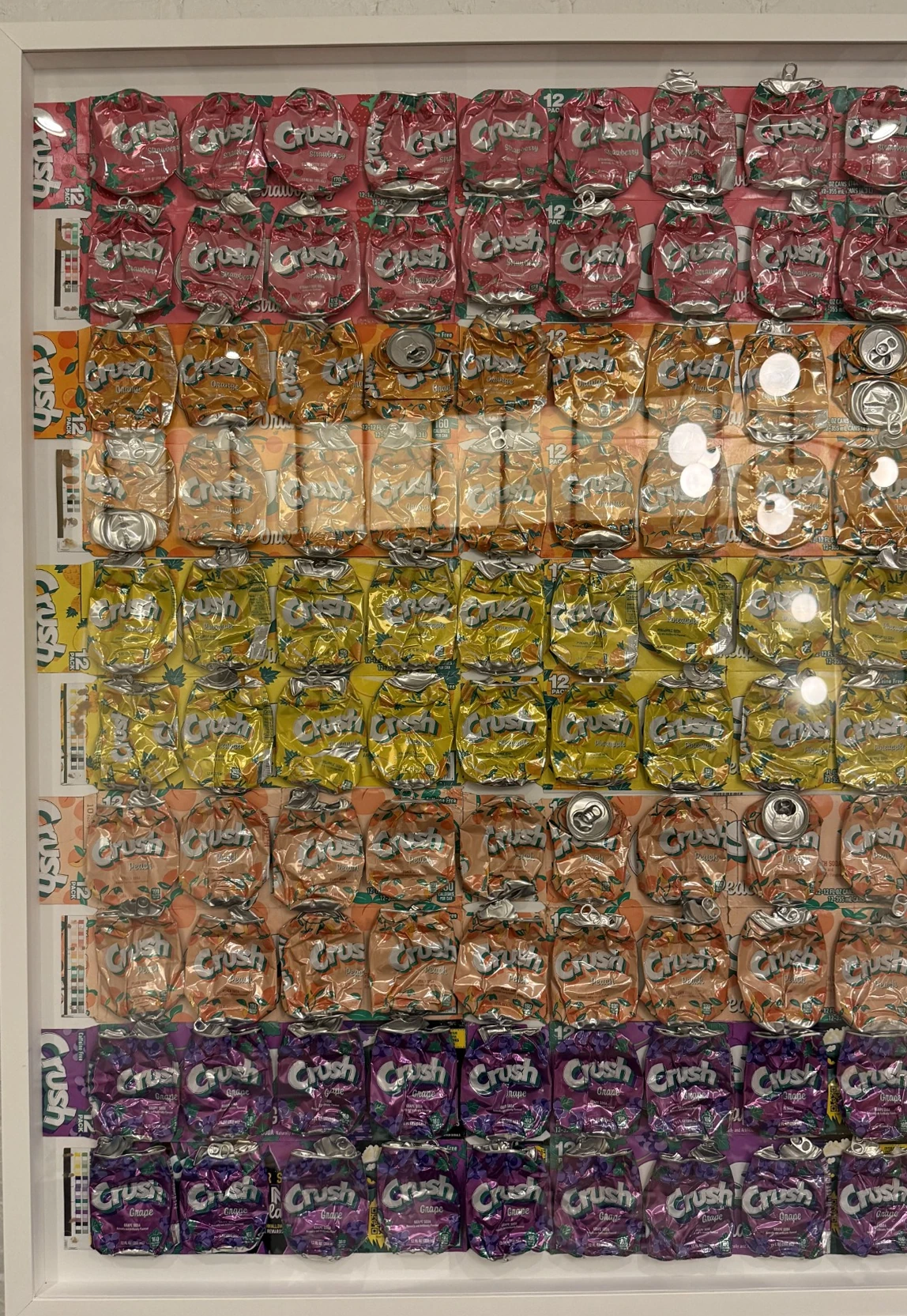 Framed wall piece of flattened colorful Crush soda cans arranged in rows