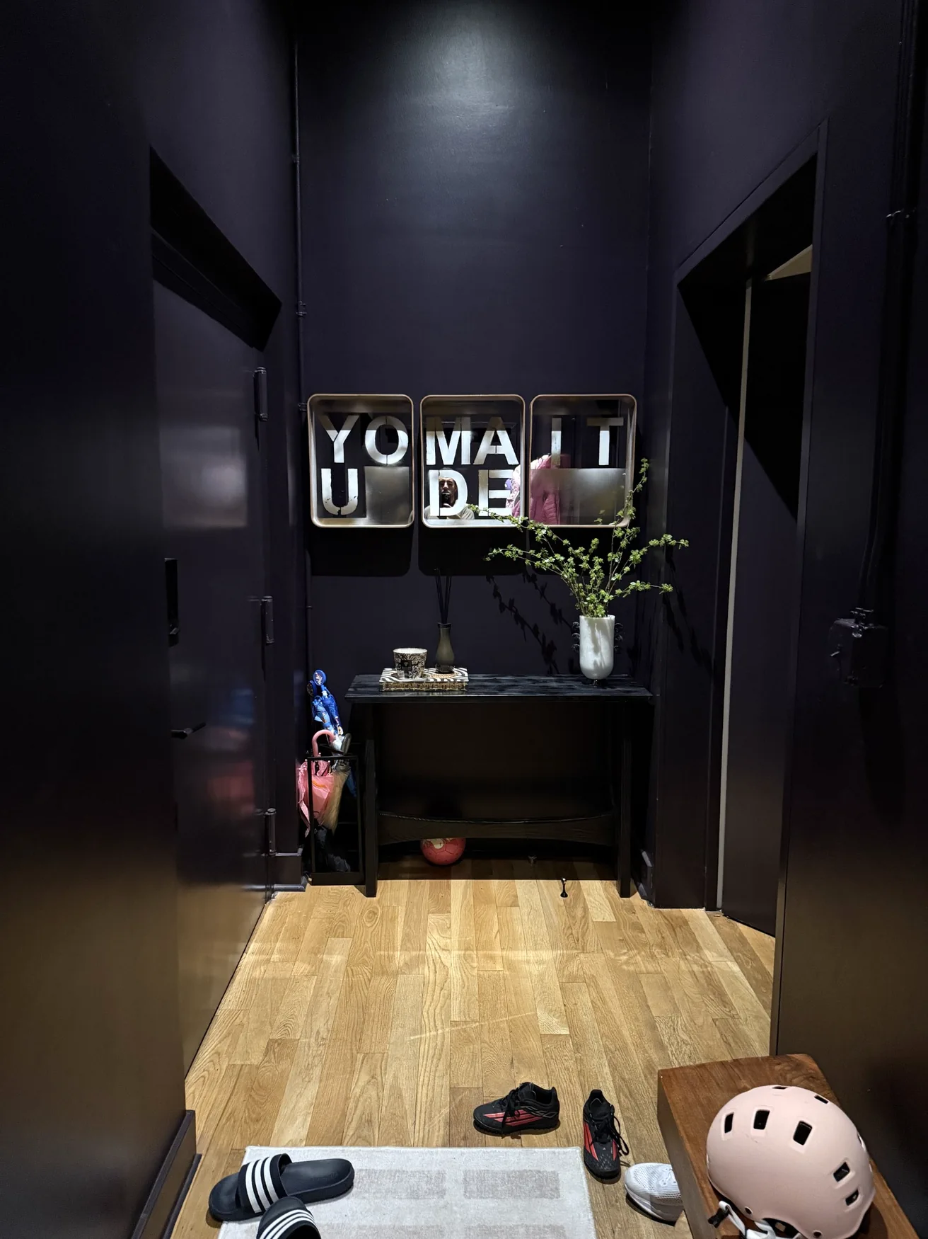 YOU MADE IT artwork installed above a console in a dark New York interior
